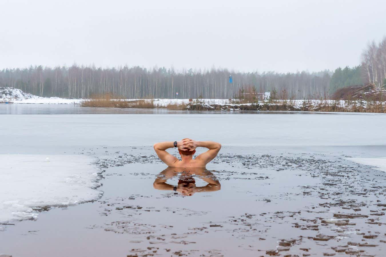 2YF8KFA A man takes the ice bath in frozen lake, the icy water providing a refreshing and invigorating experience during winter swimming