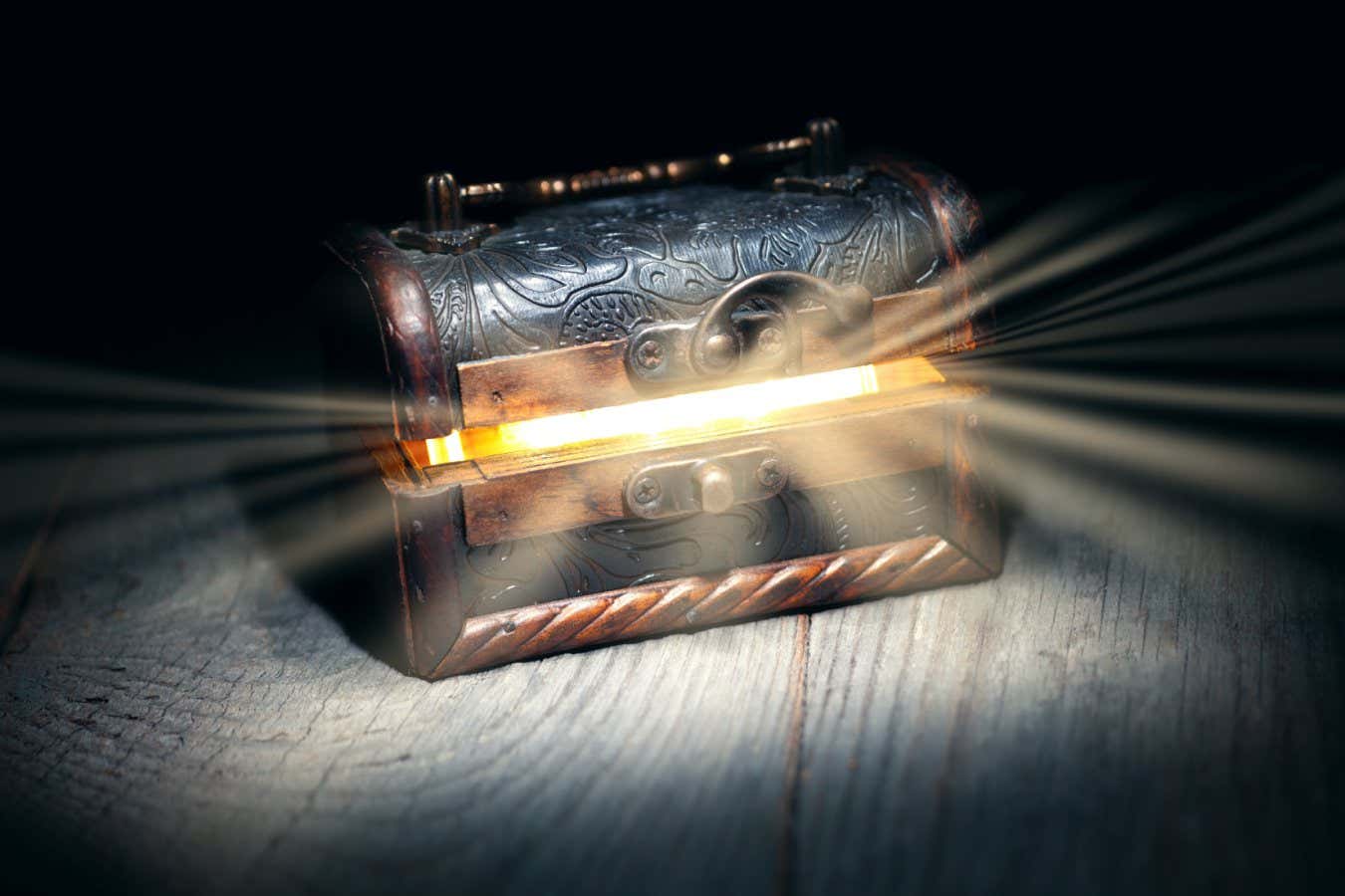 Glowing bright rays of light from an old, open wooden dark brown treasure chest, the concept of a surprise, gift, pandora's box; Shutterstock ID 2226392419; purchase_order: -; job: -; client: -; other: -